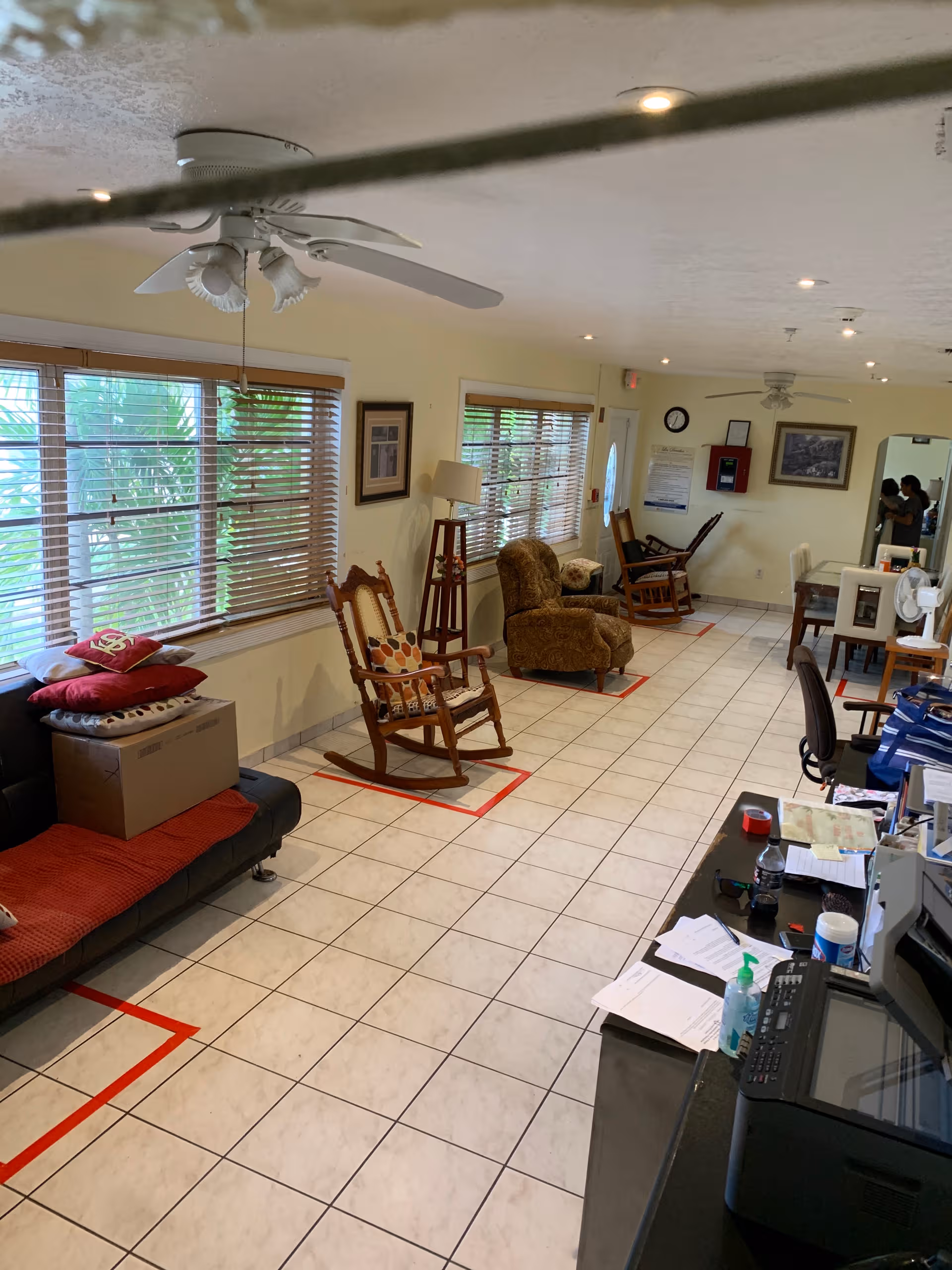 Bj Home Care communal living area with windows, rocking chairs, and a reception desk.