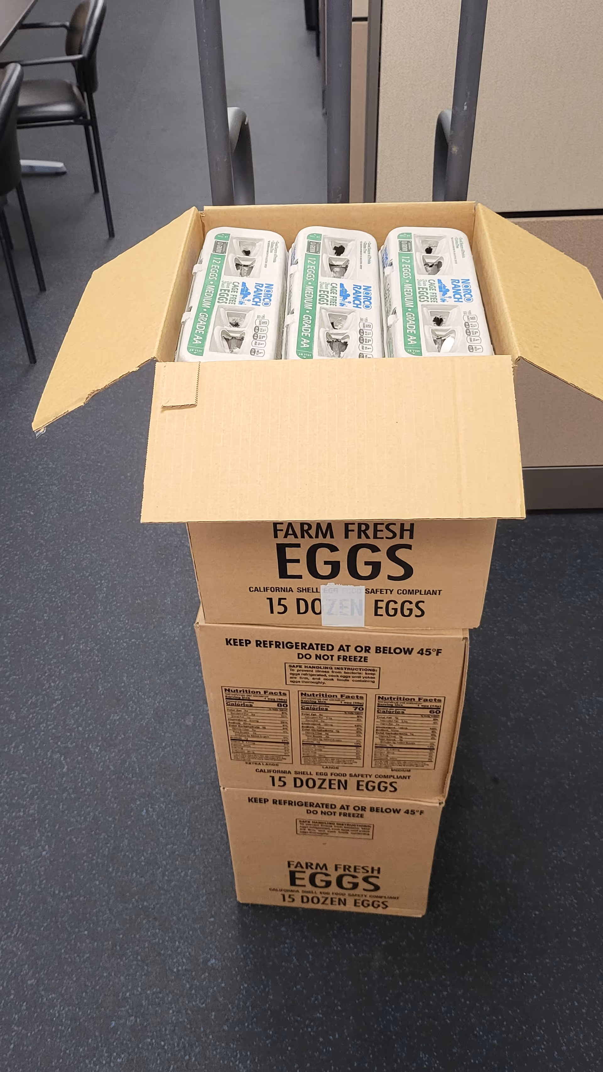 Cardboard box of farm-fresh eggs inside a facility storage area.