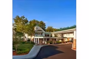Exterior view of Hanover Hill Health Care Center entrance with driveway, trees, and walkway.