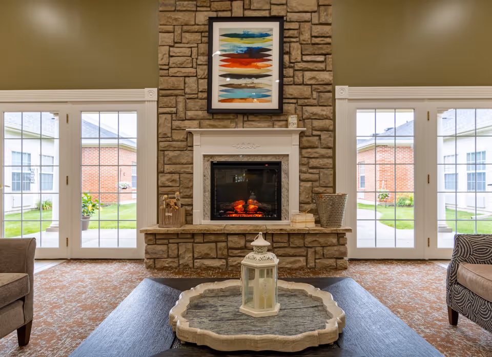 Stone fireplace centered with framed art above, glass doors on both sides.