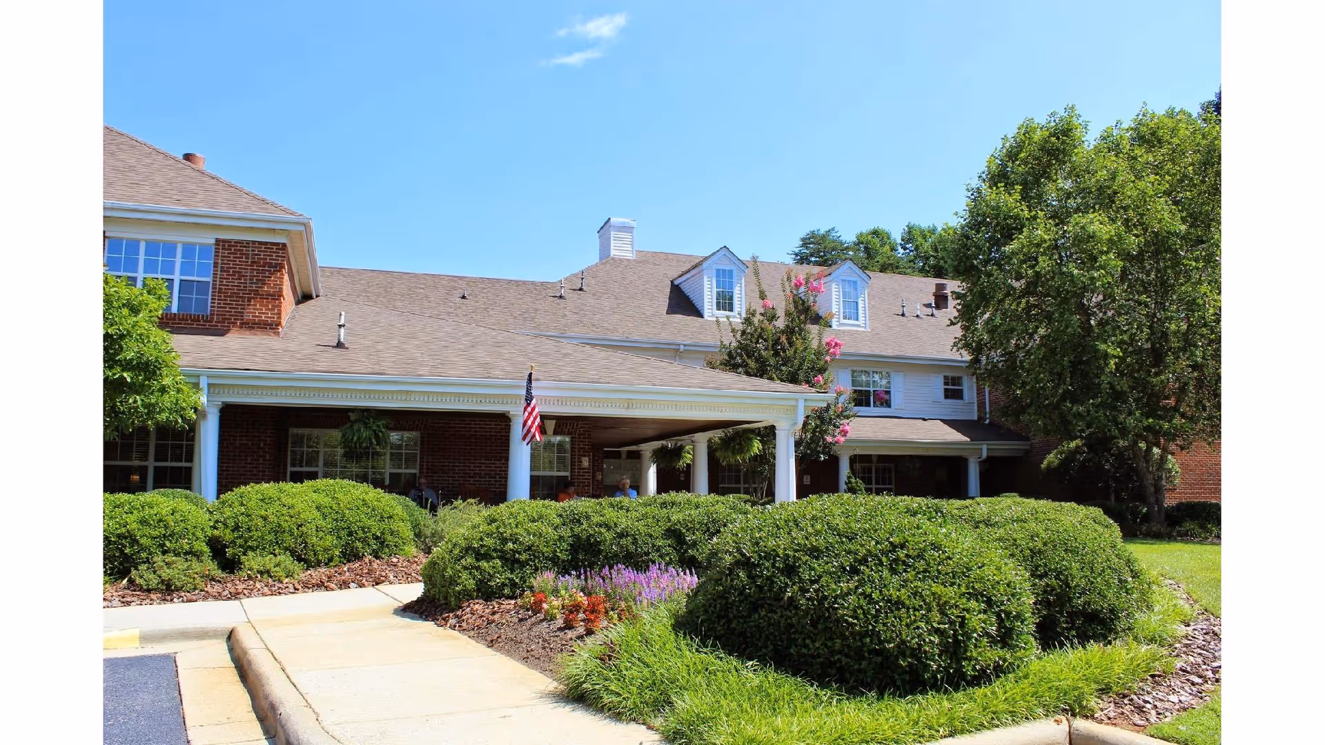 Exterior view of Carriage House Senior Living Community with front entrance and manicured landscaping.