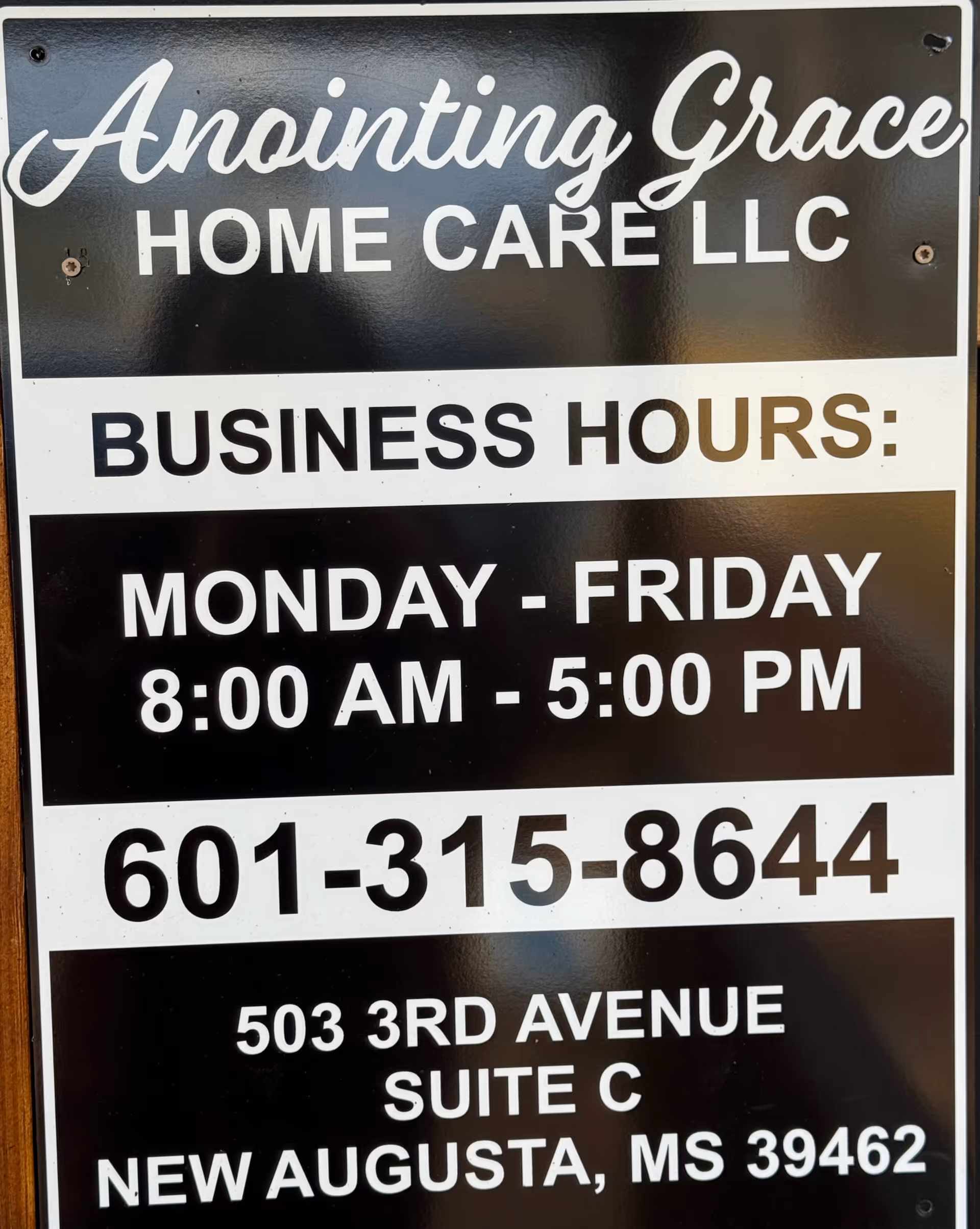 Sign displays Anointing Grace Home Care LLC with business hours and address.