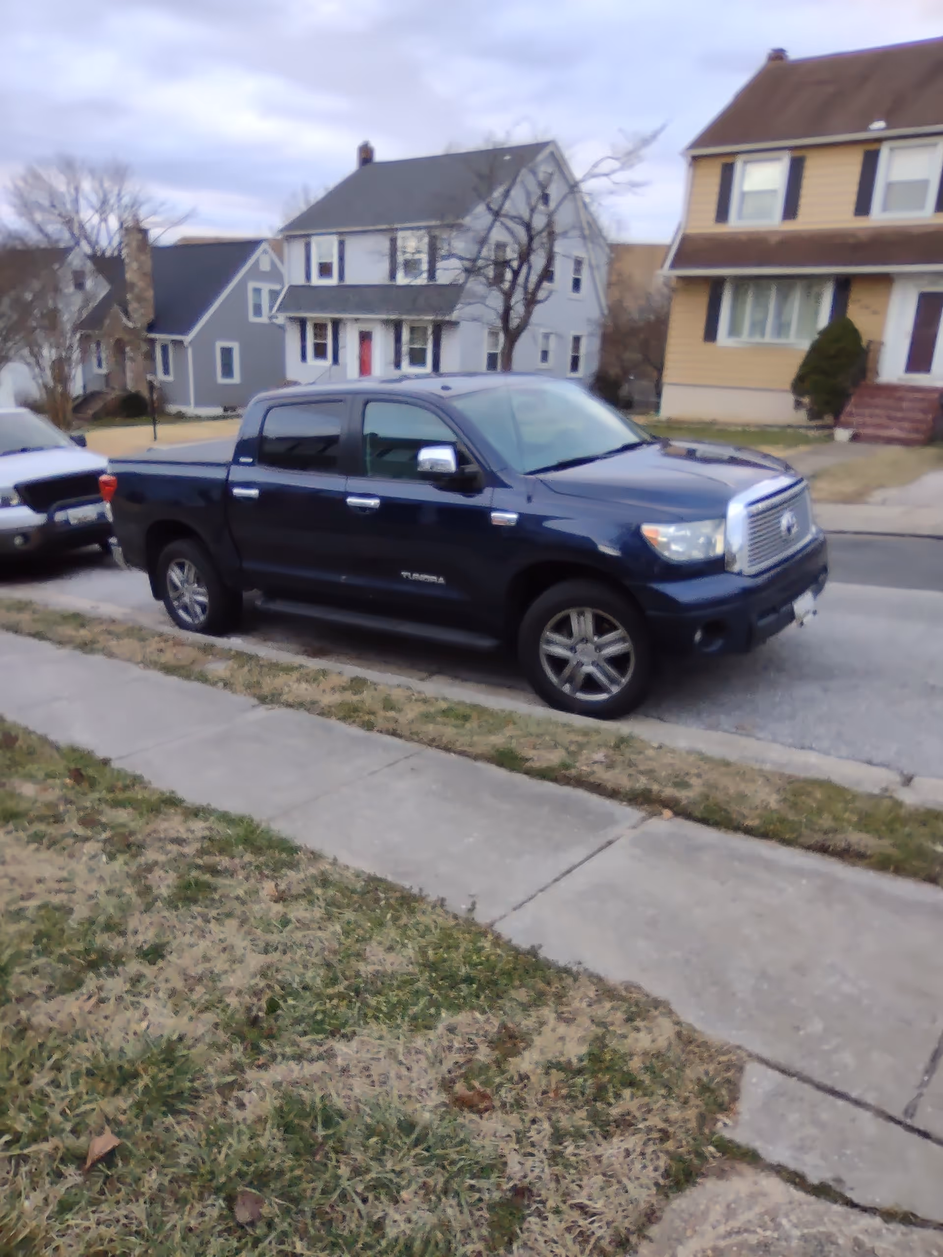 A dark blue Toyota Tundra pickup truck parked on a residential street.