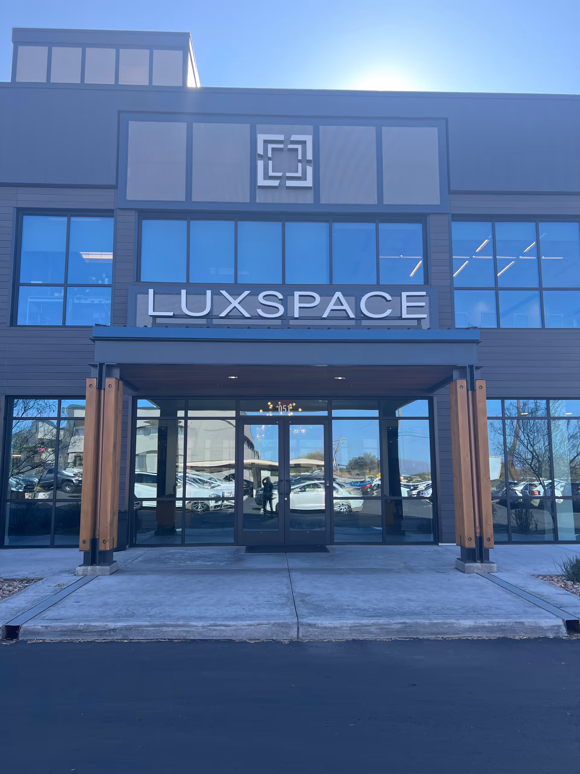 Exterior view of a modern building entrance with LuxSpace sign.