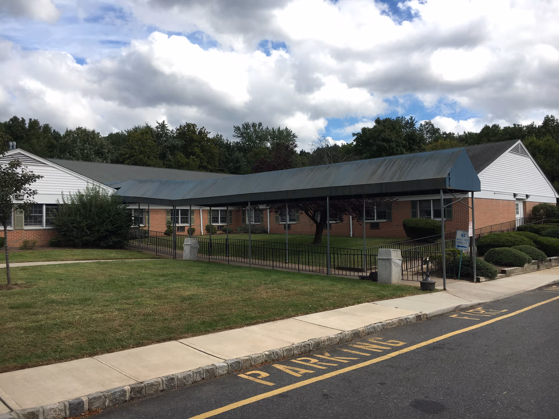 Exterior view of a single-story senior facility with brick walls and a covered entrance.