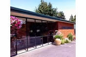 Exterior view of Alderwood Park Health and Rehabilitation with glass entry and potted plants.
