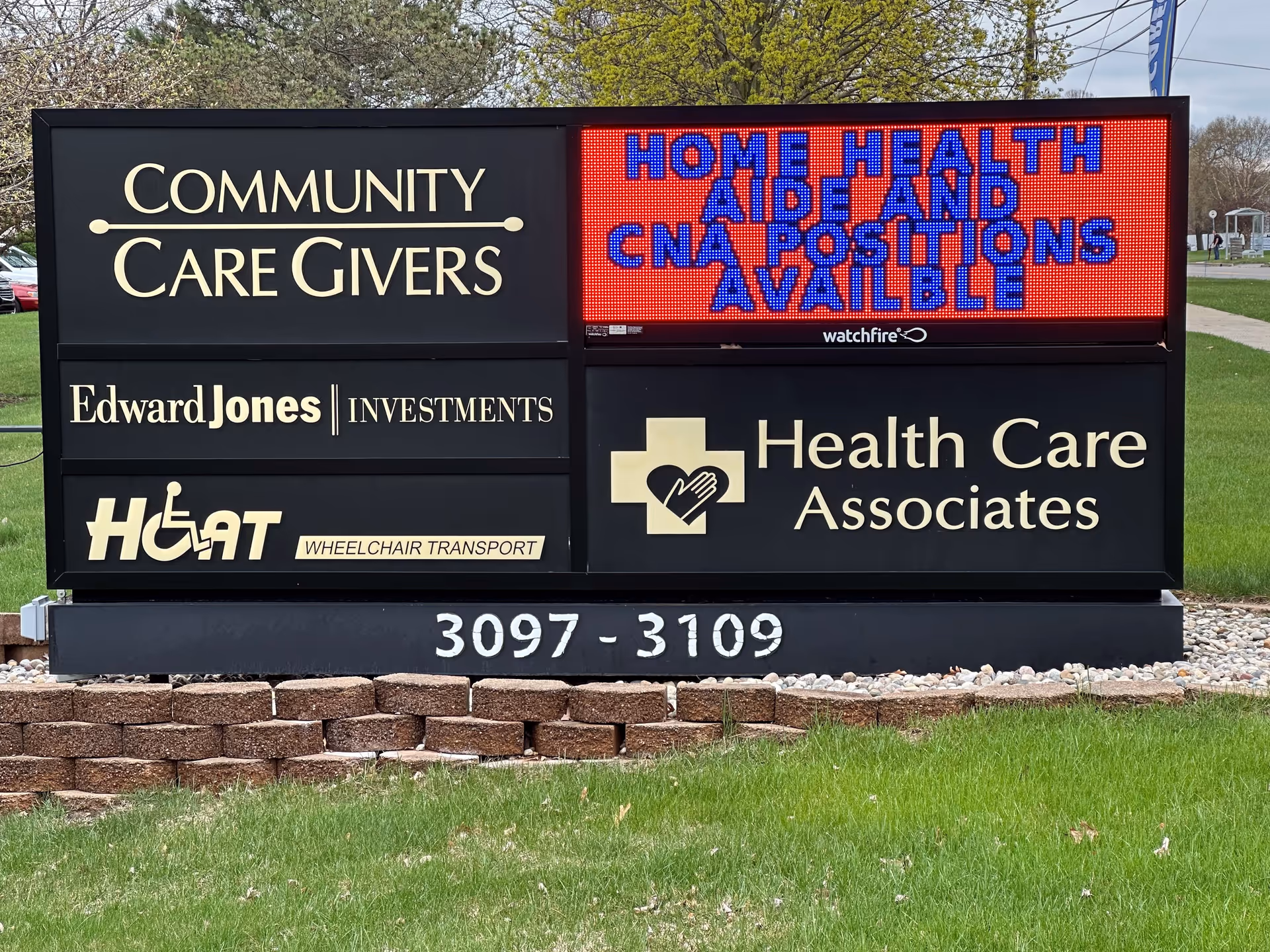 A large outdoor signboard displays Health Care Associates and Community Care Givers.