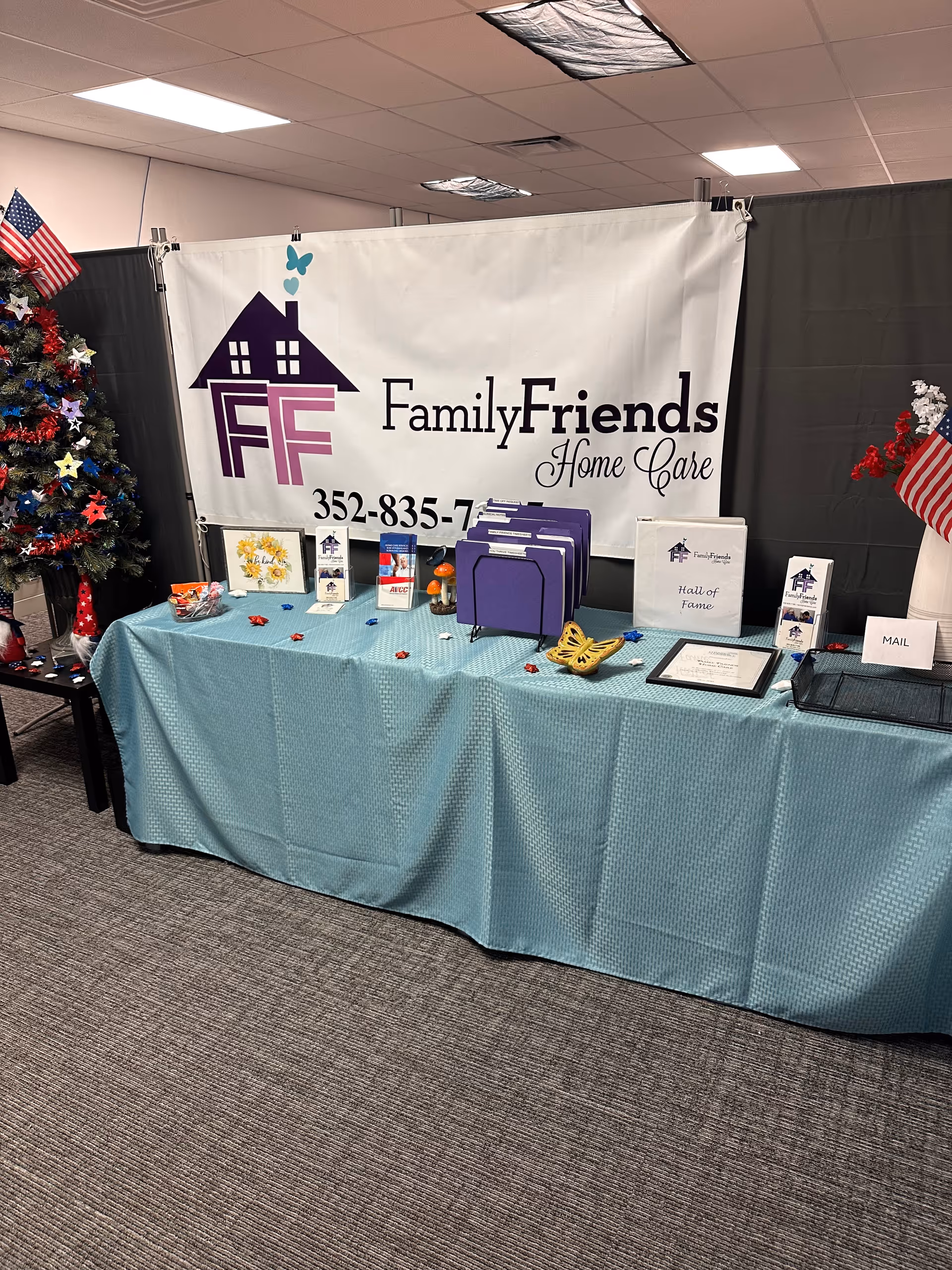 Indoor expo booth for Family & Friends Home Care with banner, brochures, and table setup.
