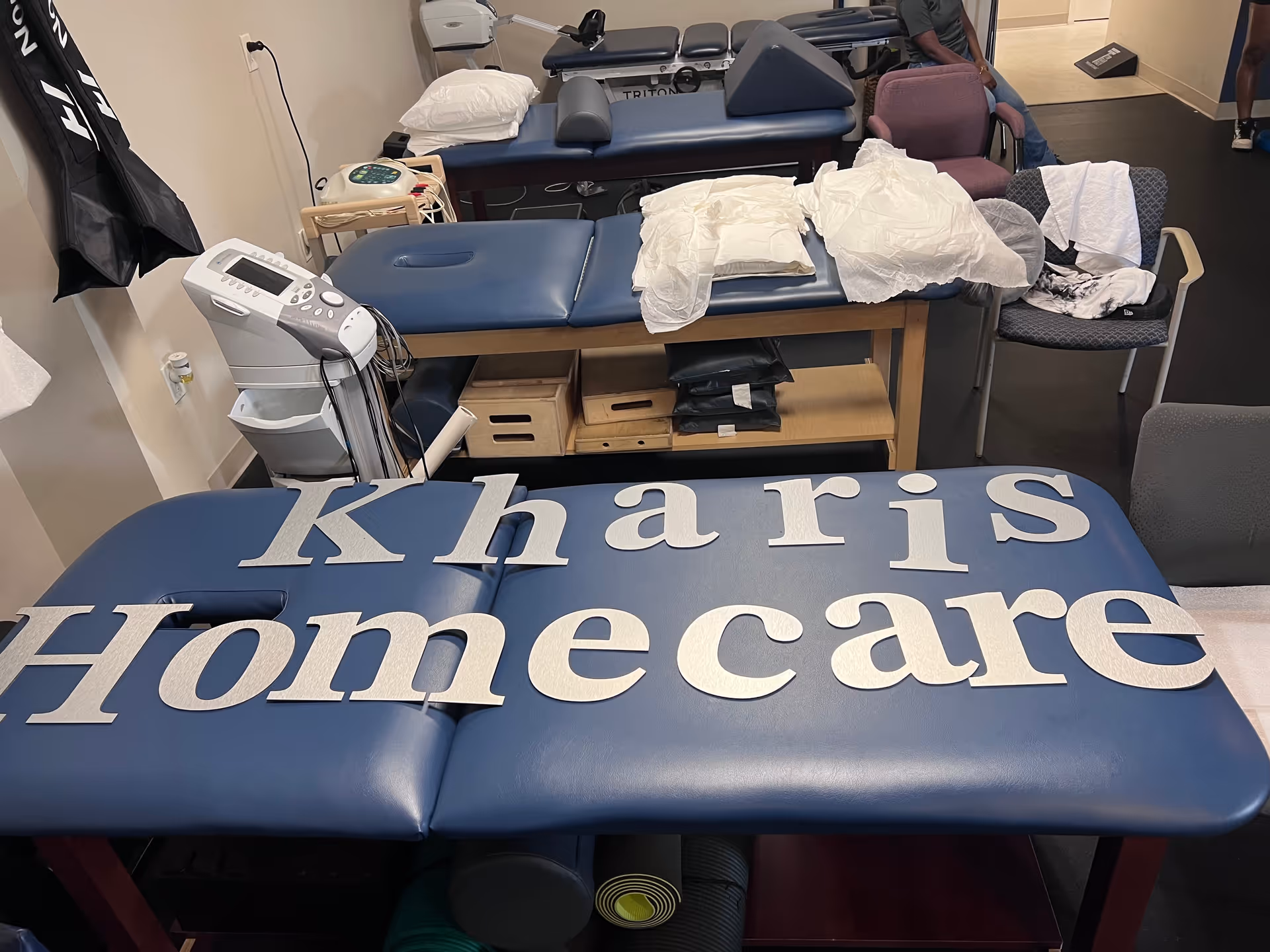 Treatment room with blue therapy tables and medical equipment at a homecare facility.