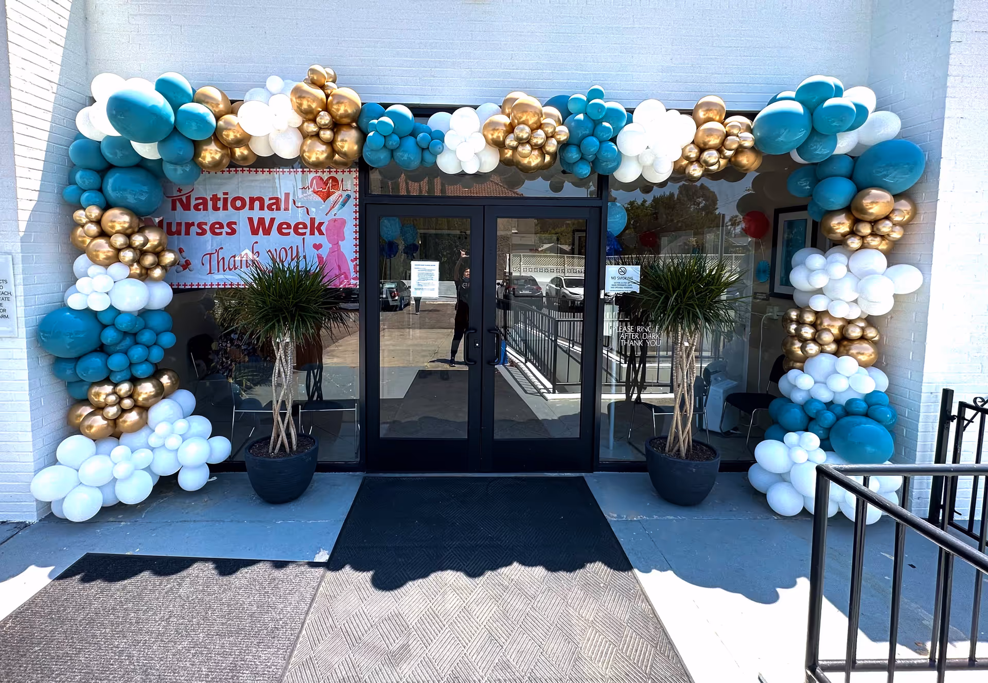 Entrance to Country Villa North with teal, white, and gold balloon arch