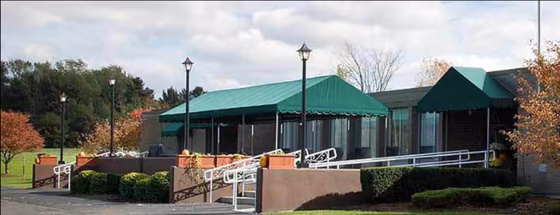 Exterior view of Eden Heights of Eden with green awnings and accessible ramp.