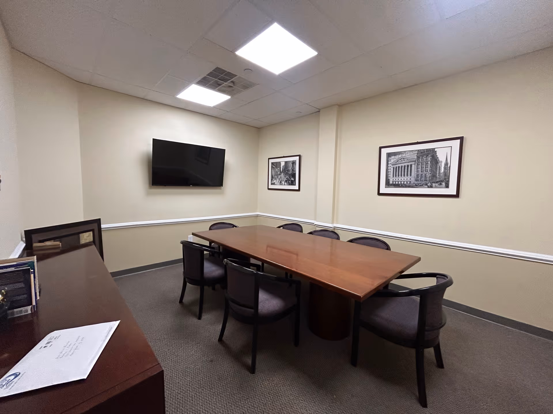 A conference-style meeting room in a senior living facility with a long wooden table and chairs.