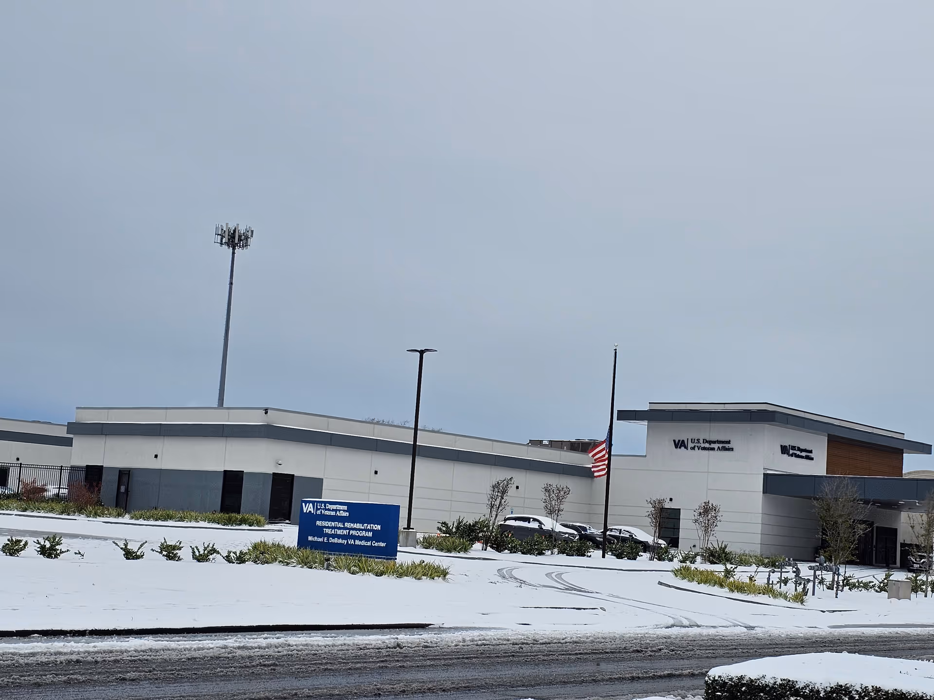 Snow-covered exterior of a U.S. Department of Veterans Affairs facility with flag
