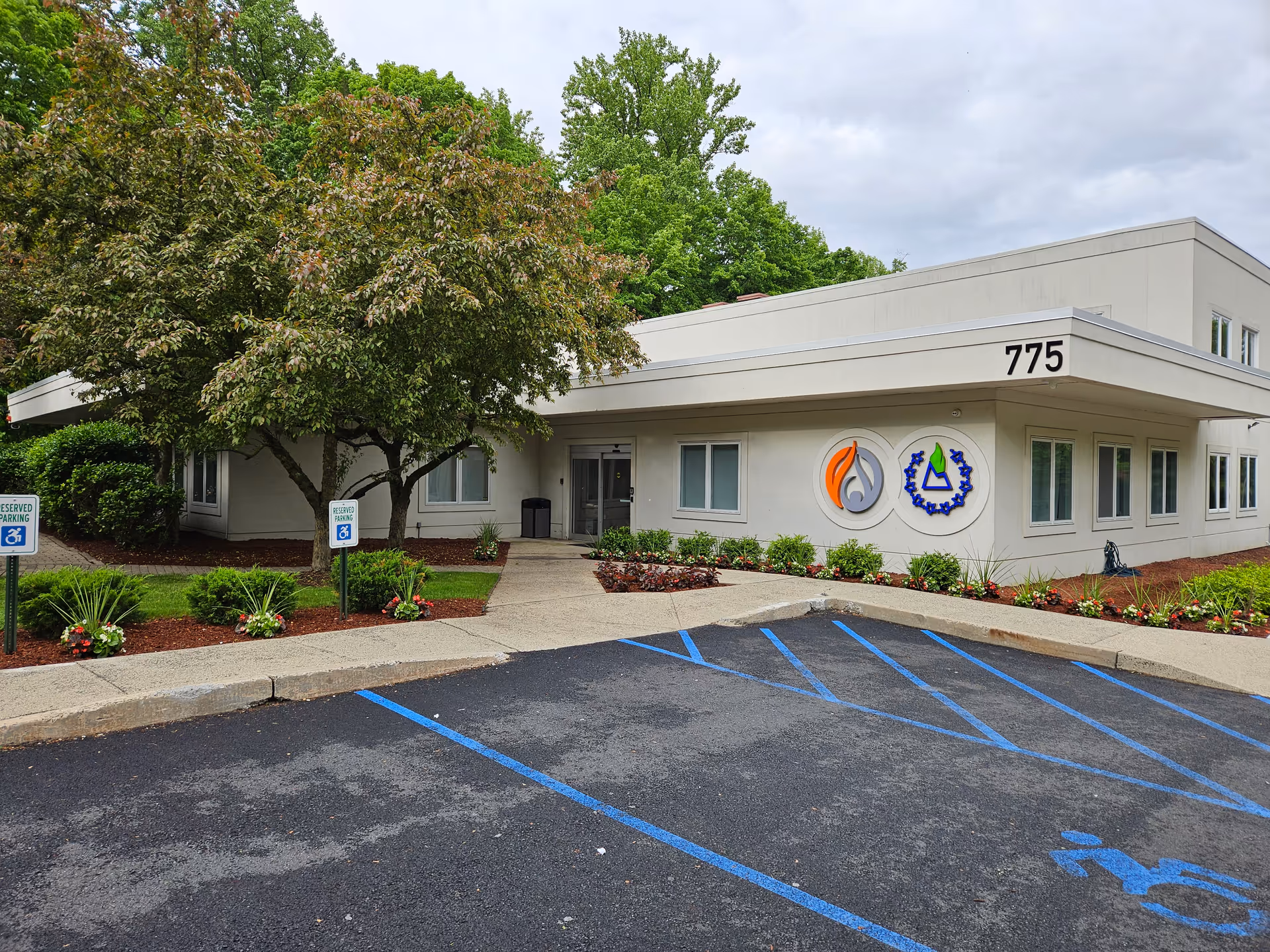 A single-story facility exterior with a front entrance, parking lot, and landscaped approach.