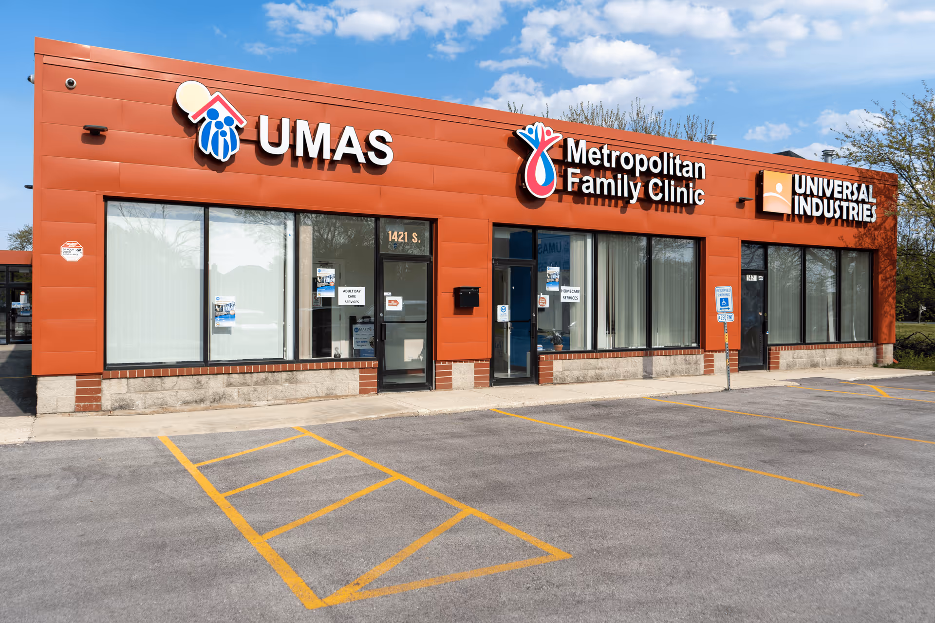 Red storefront with large windows and signs for UMAS and Metropolitan Family Clinic