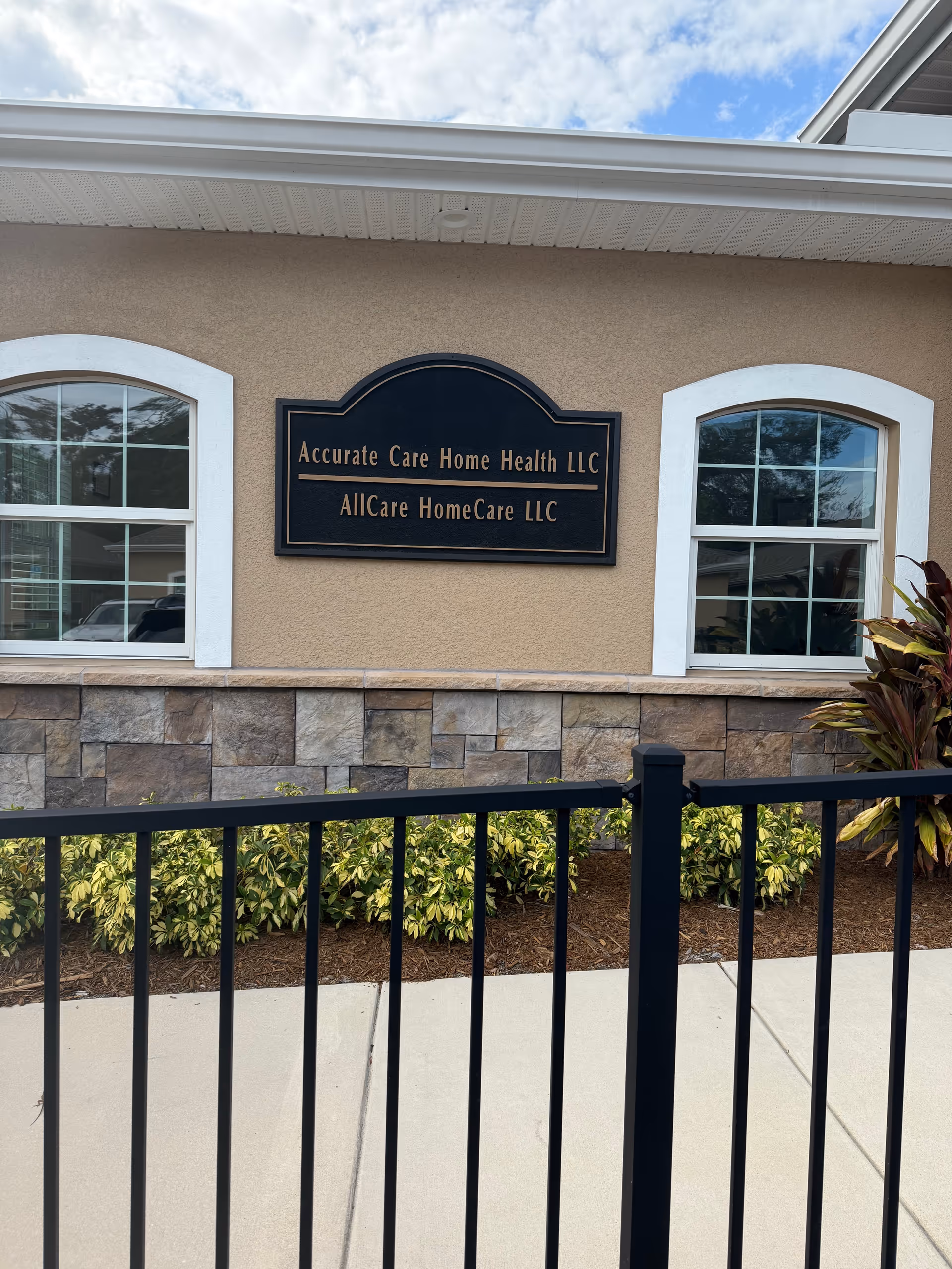 Facade of Accurate Care Home Health LLC building with sign, front windows, and landscaping.