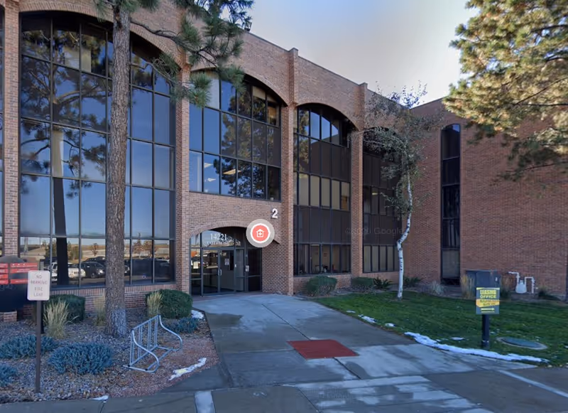 Front view of a brick Virtue Care facility with large windows and a paved entrance.