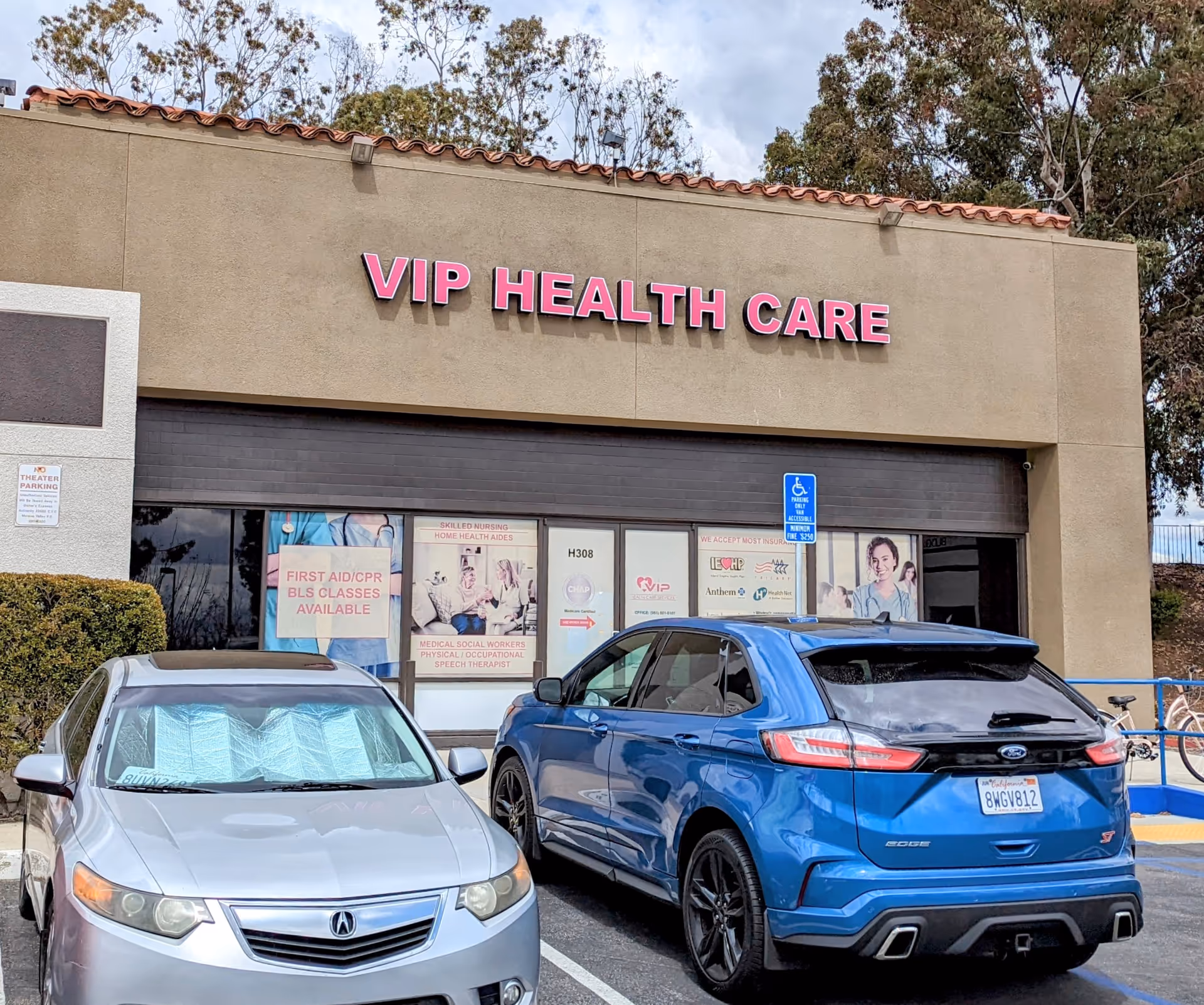 VIP Health Care storefront with pink sign, glass doors, and parked cars in front.
