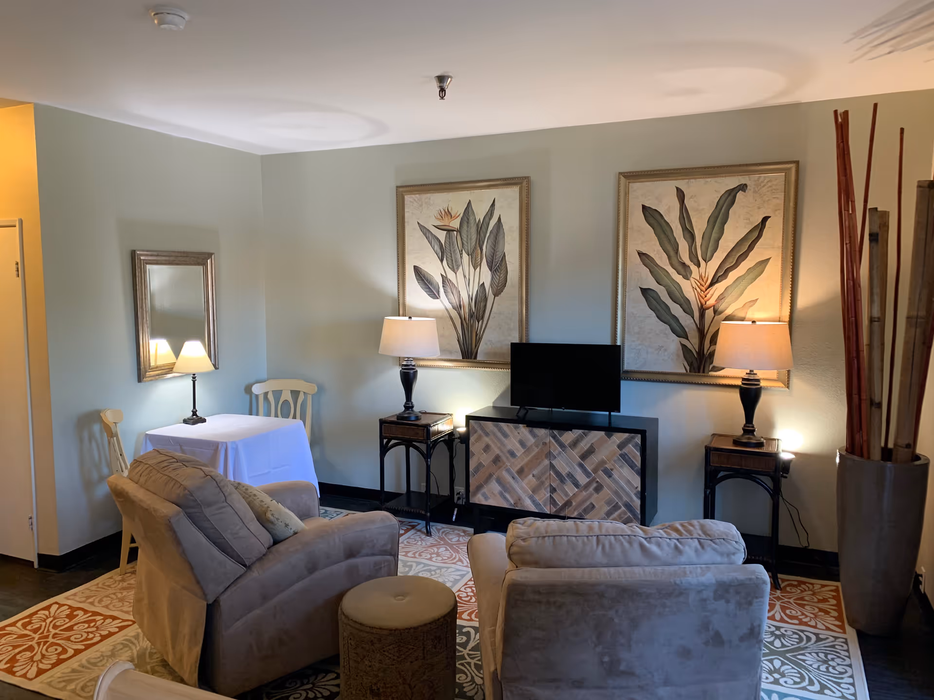 Cozy living room in Windsor Court with sofas, lamps, a TV, and framed art.