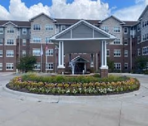 Exterior view of The Gardens at Jackson Creek entrance with a circular flower bed.