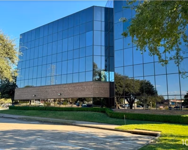 Exterior of Rehab Accomplished Inc. building with a glass facade and landscaped grounds.