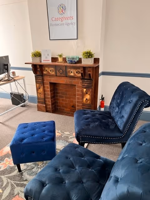 Blue tufted chairs and ottoman sit in a cozy living room with a fireplace.