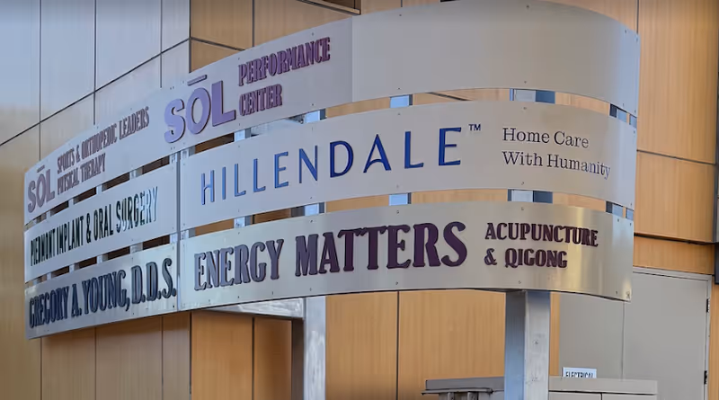 Curved exterior signboard outside Hillendale Home Care listing services and tenants.