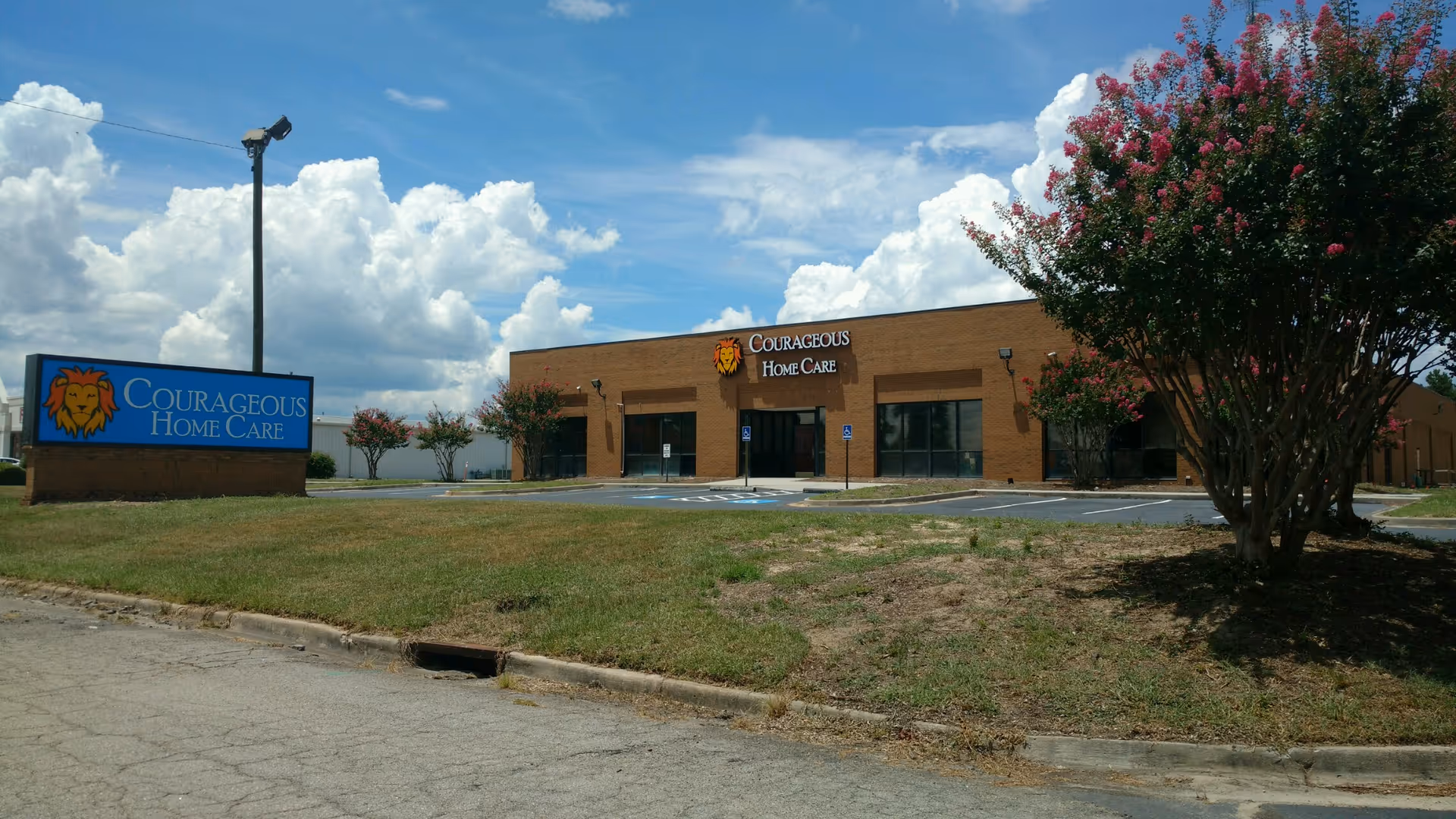 Exterior view of Courageous Home Care facility with signage and parking lot.