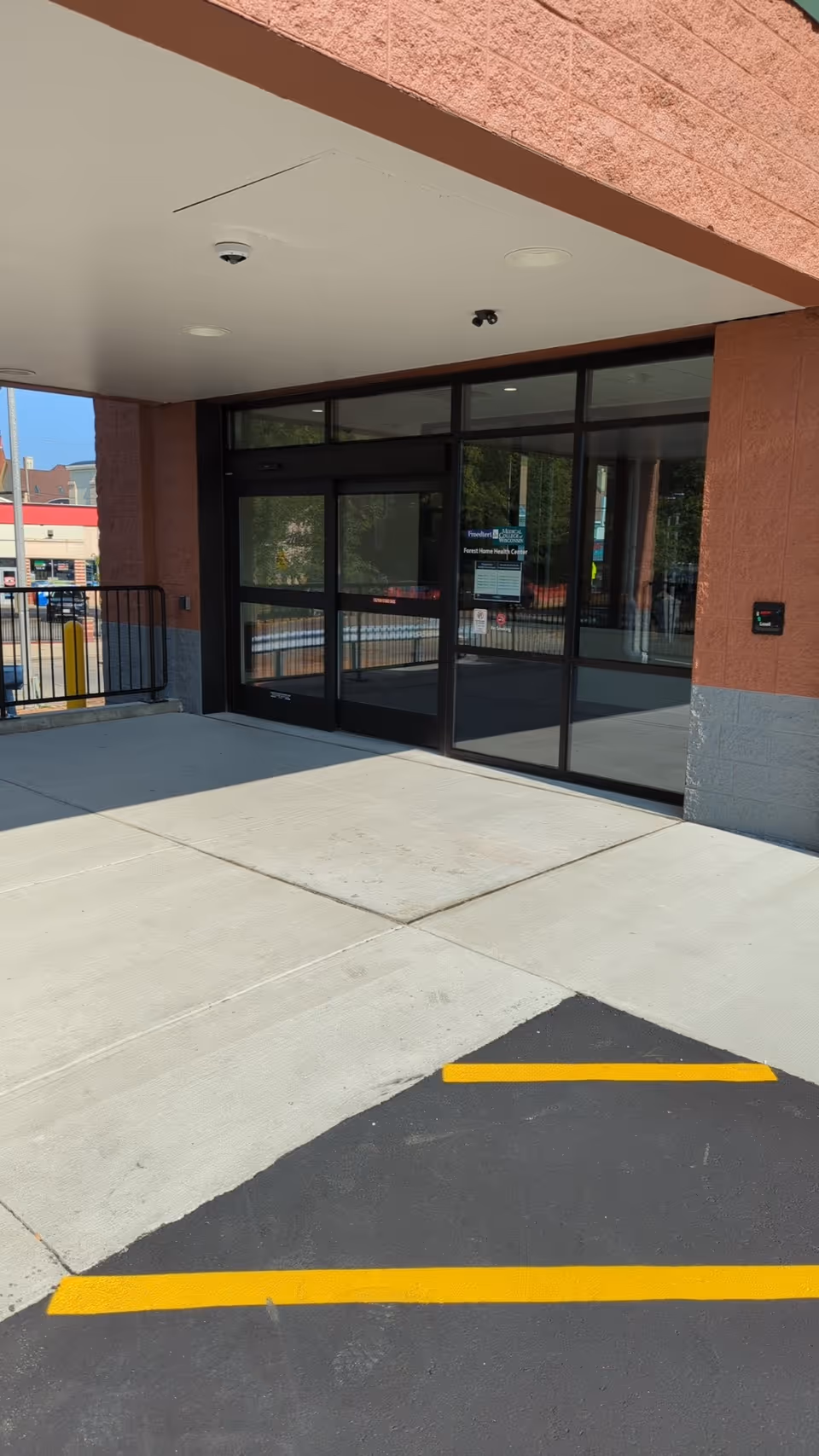 Exterior view of Forest Home Health Center entrance with glass doors under a covered entryway.