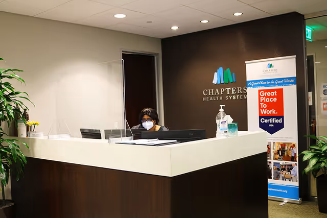 Reception desk in Chapters Health System office with masked staff member