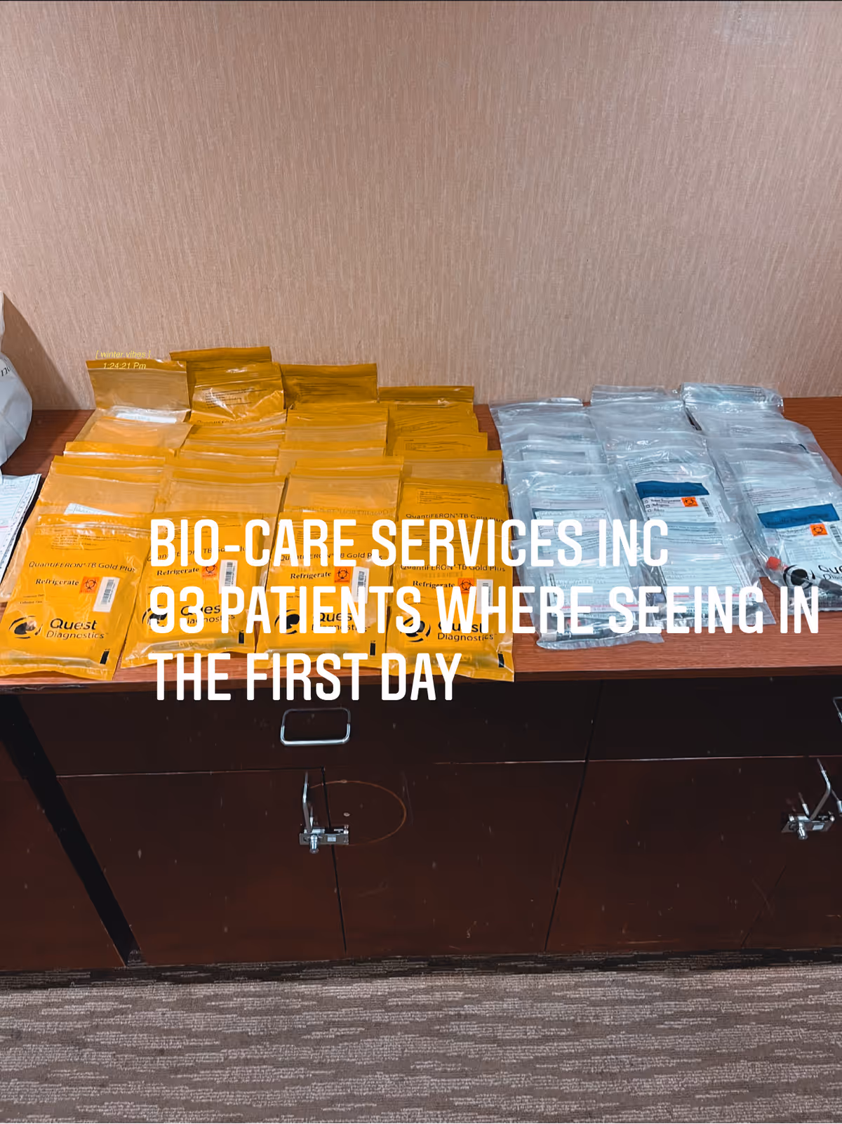 Rows of yellow and blue medical packets arranged on a dark cabinet in a facility.