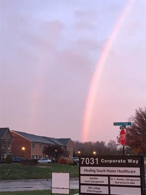 Exterior view of Ally College senior facility with rainbow over street sign in foreground