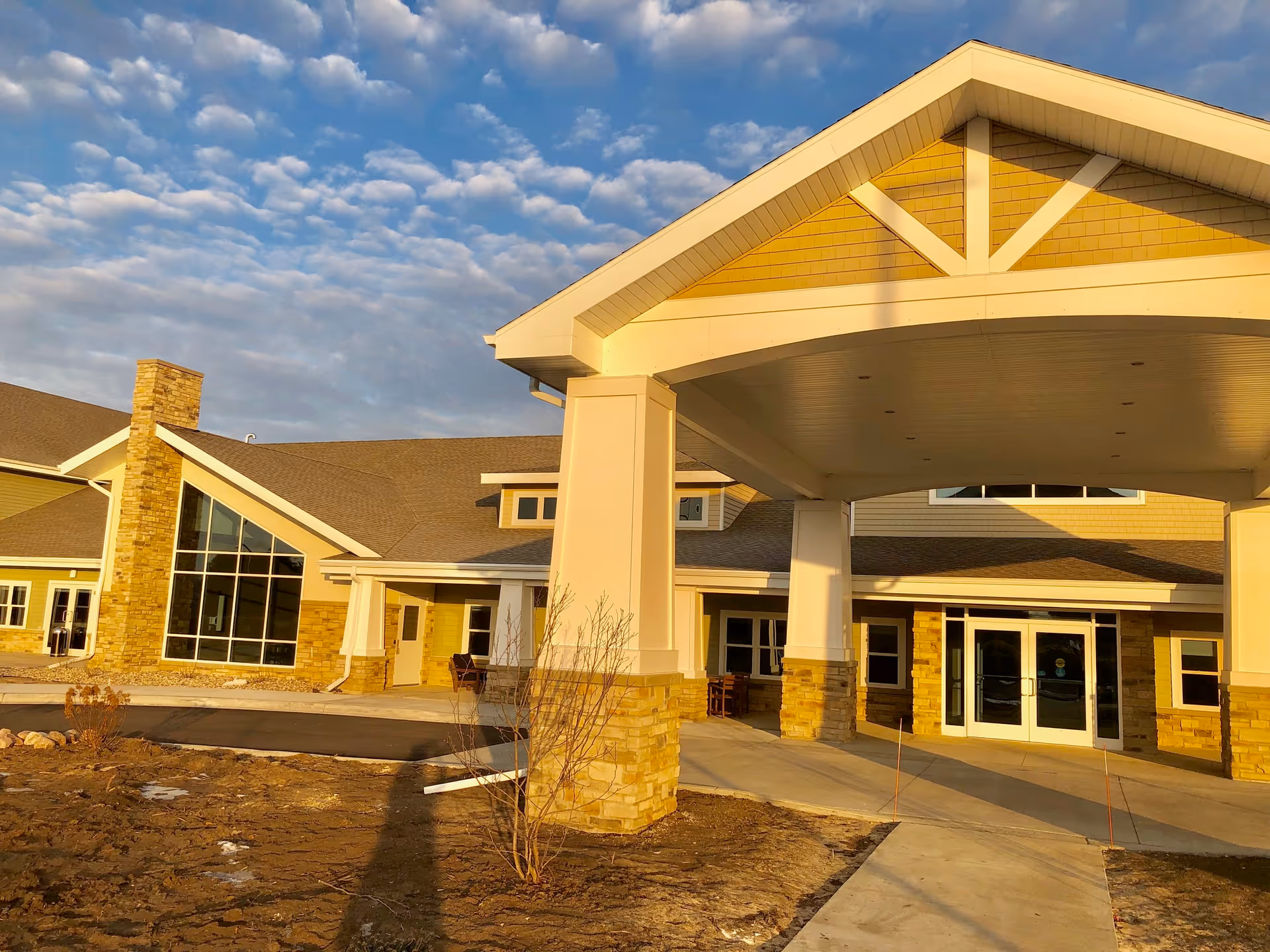Front view of a senior living center entrance with a large covered portico.