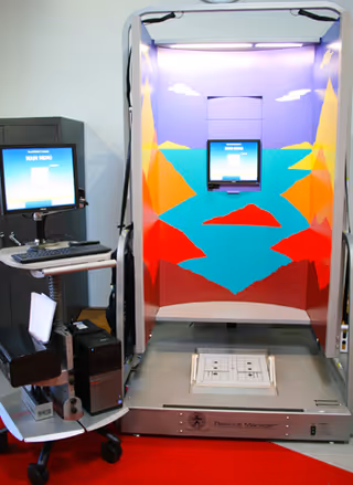 Bright rehabilitation booth with colorful wall art and computer monitor in Excel at Woodbury clinic.