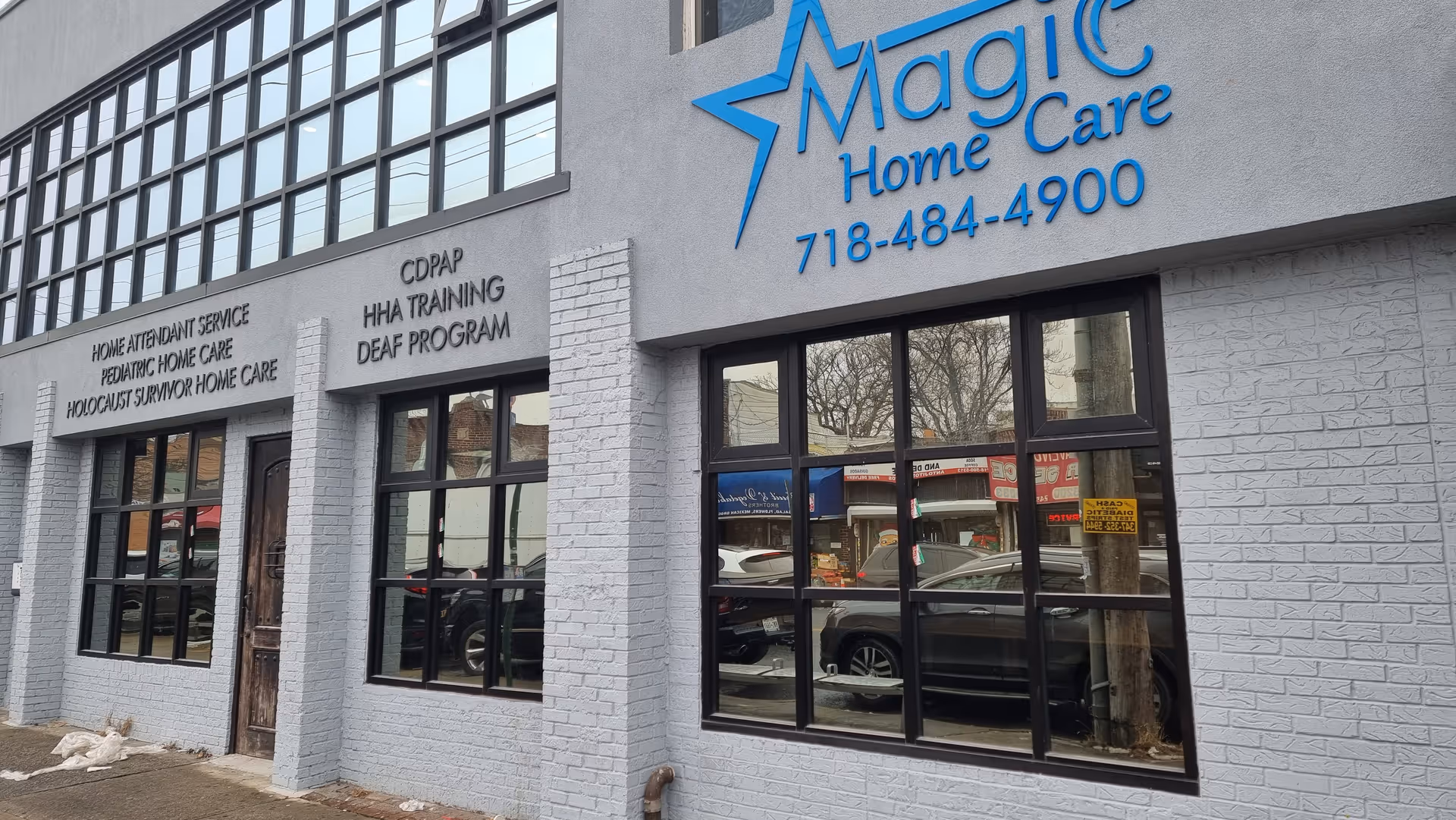 Exterior view of Magic Home Care storefront with large windows and blue sign.