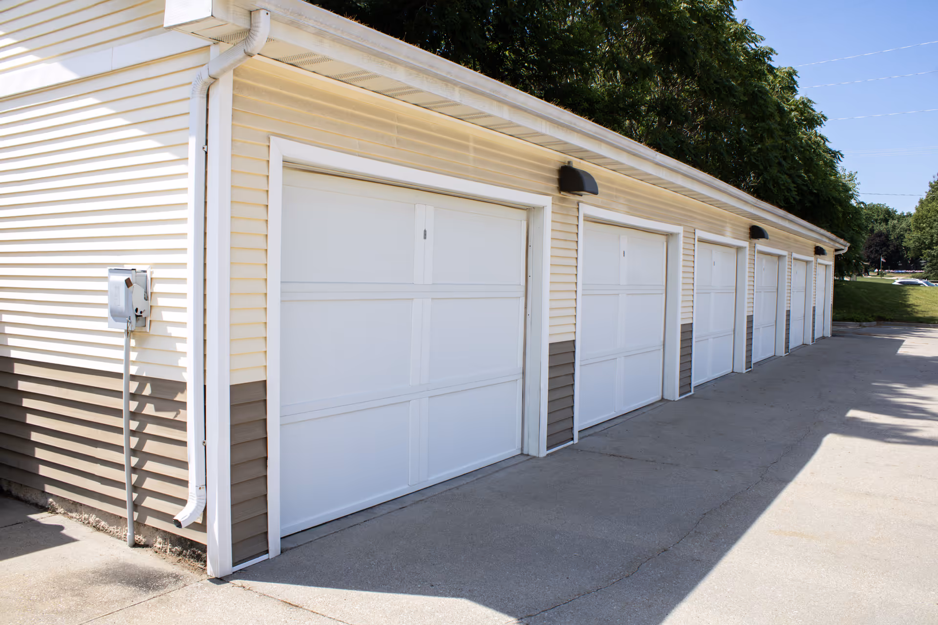 Row of white garage doors along beige vinyl-sided exterior of Carlisle Center for Wellness and Rehab.