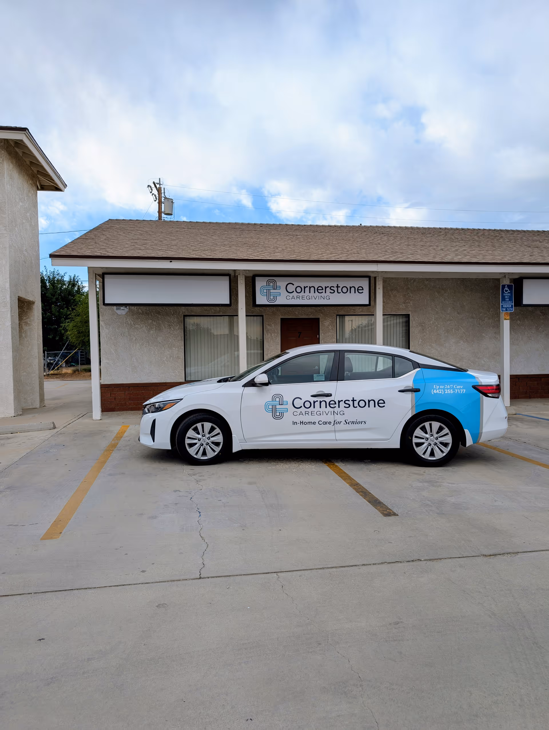 Exterior of Cornerstone Caregiving building with a branded car parked in the lot.