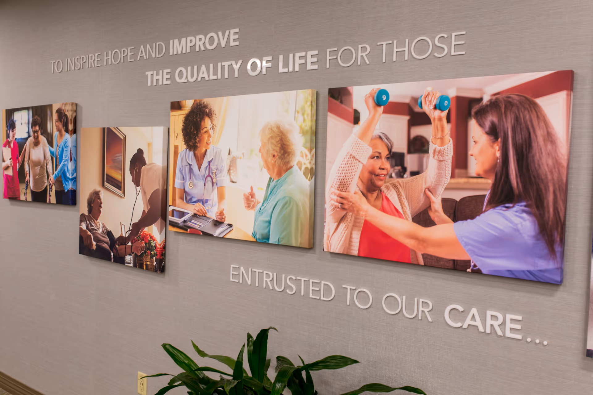 Interior hallway with multi-panel photo wall and inspirational care-themed text.