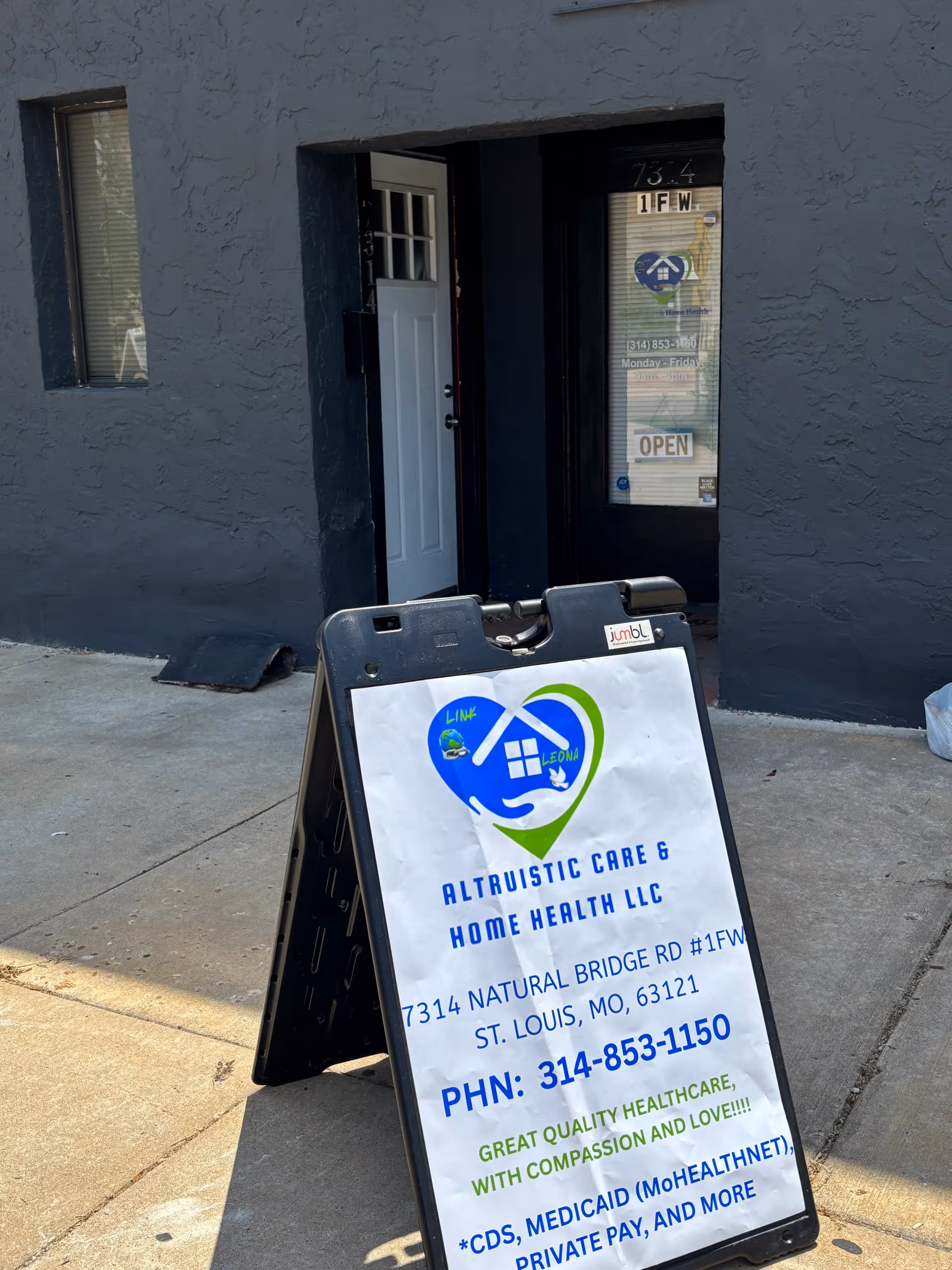 Dark exterior building entrance with a sidewalk sign advertising Altruistic Care & Home Health LLC.