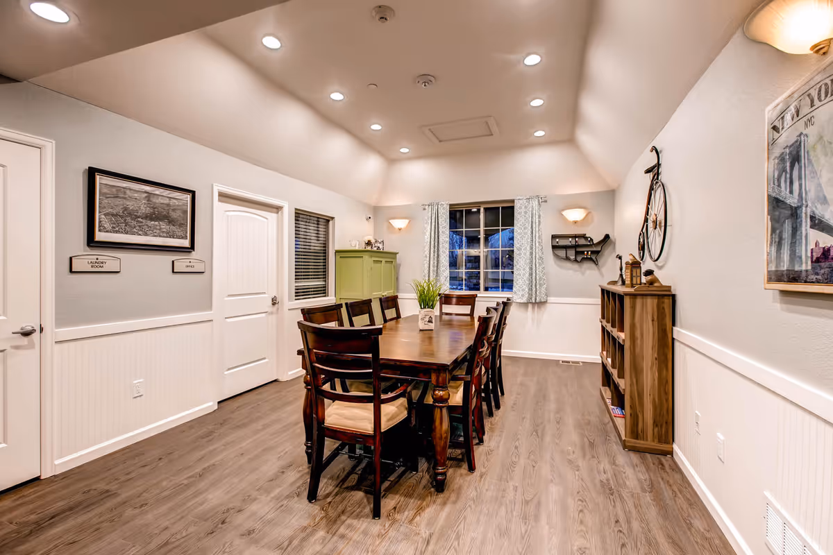 A bright dining room with a long wooden table and chairs.