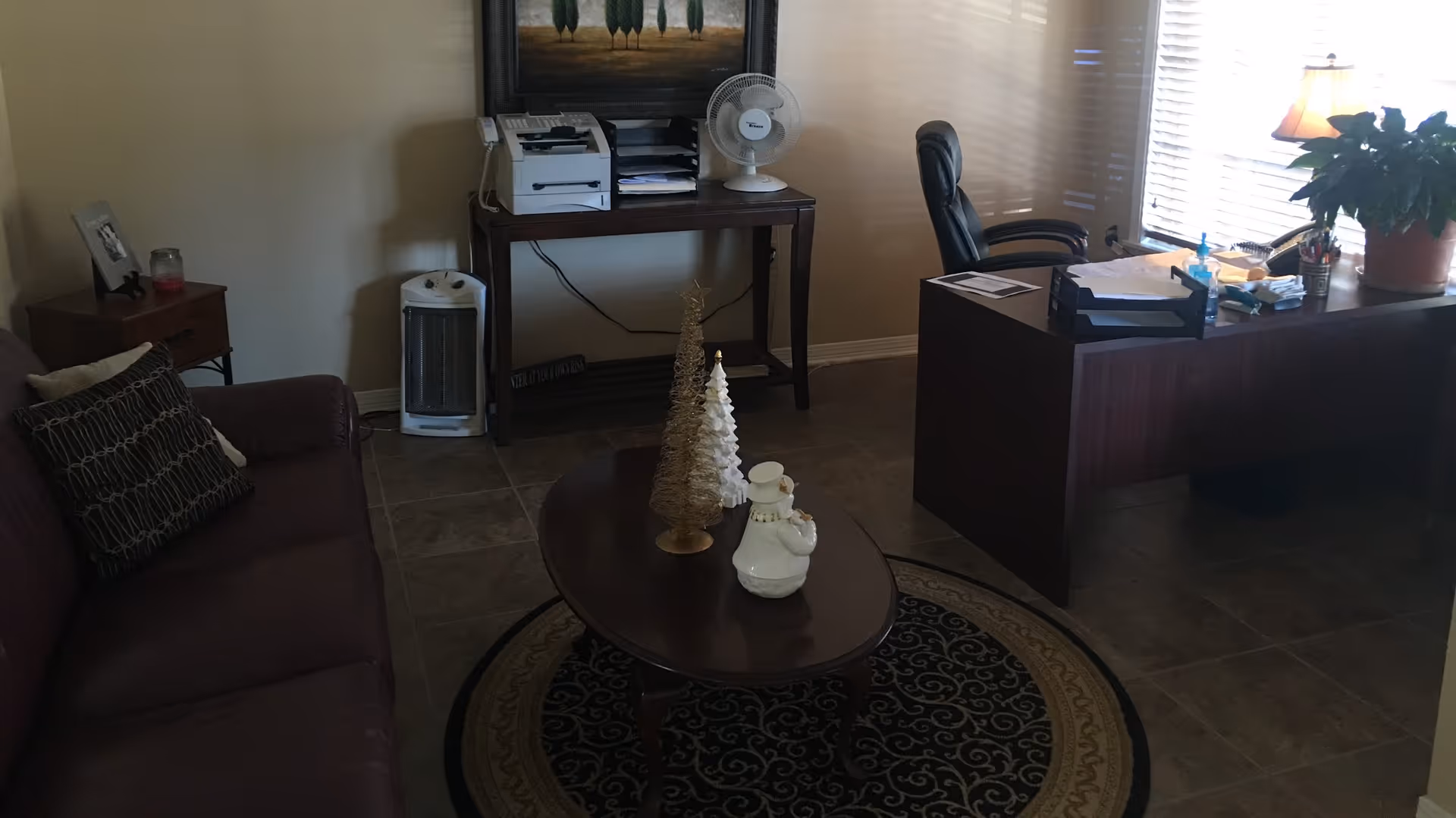 Cozy living room-style office area with desk, couch, and holiday decorations.