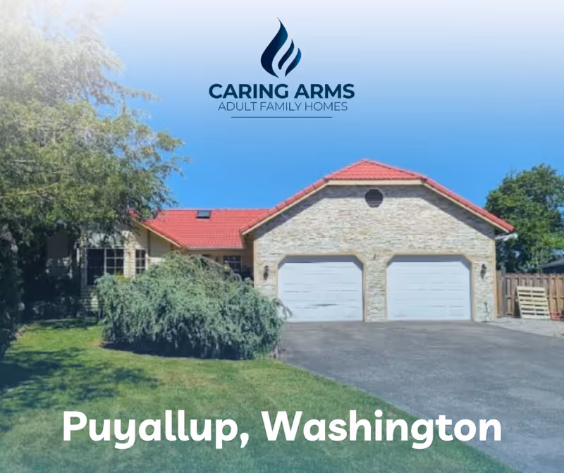 Front exterior of Caring Arms Adult Family Homes with stone facade, two garages, and green lawn.