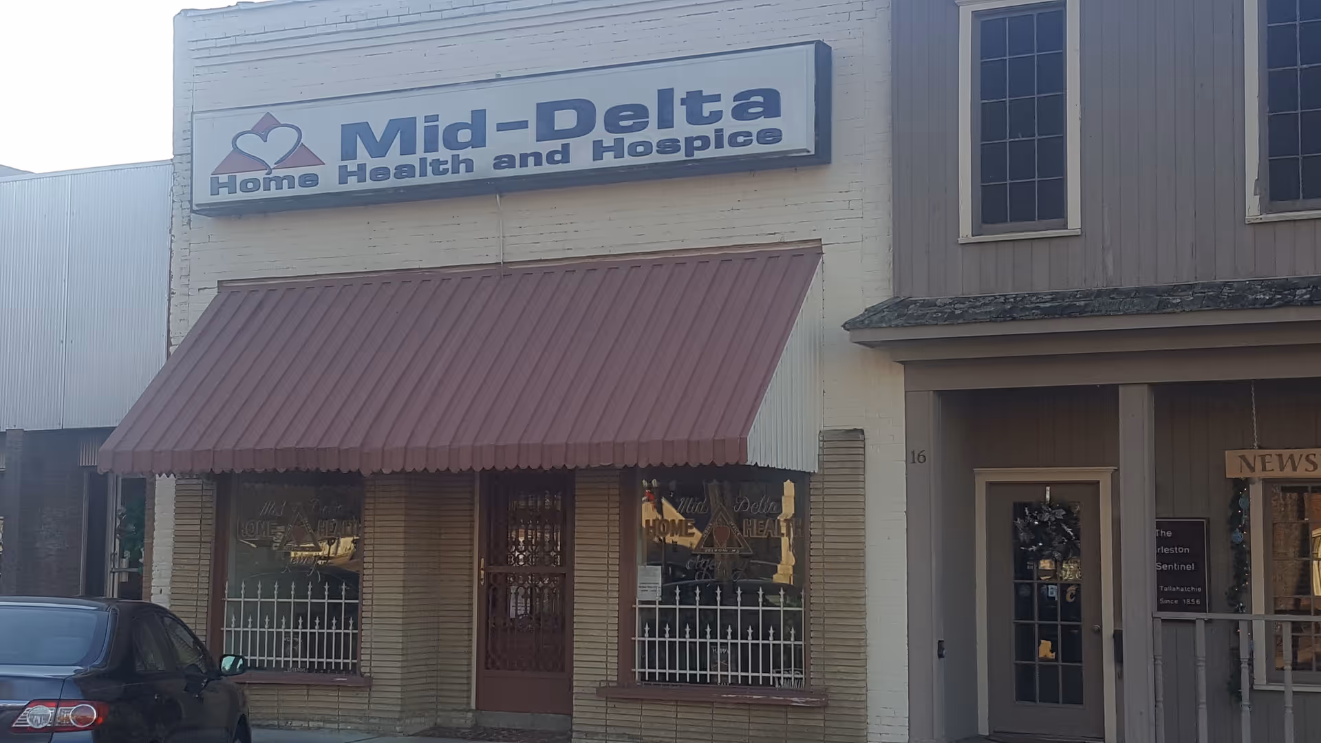 Exterior view of Mid-Delta Health and Hospice building with a red awning.