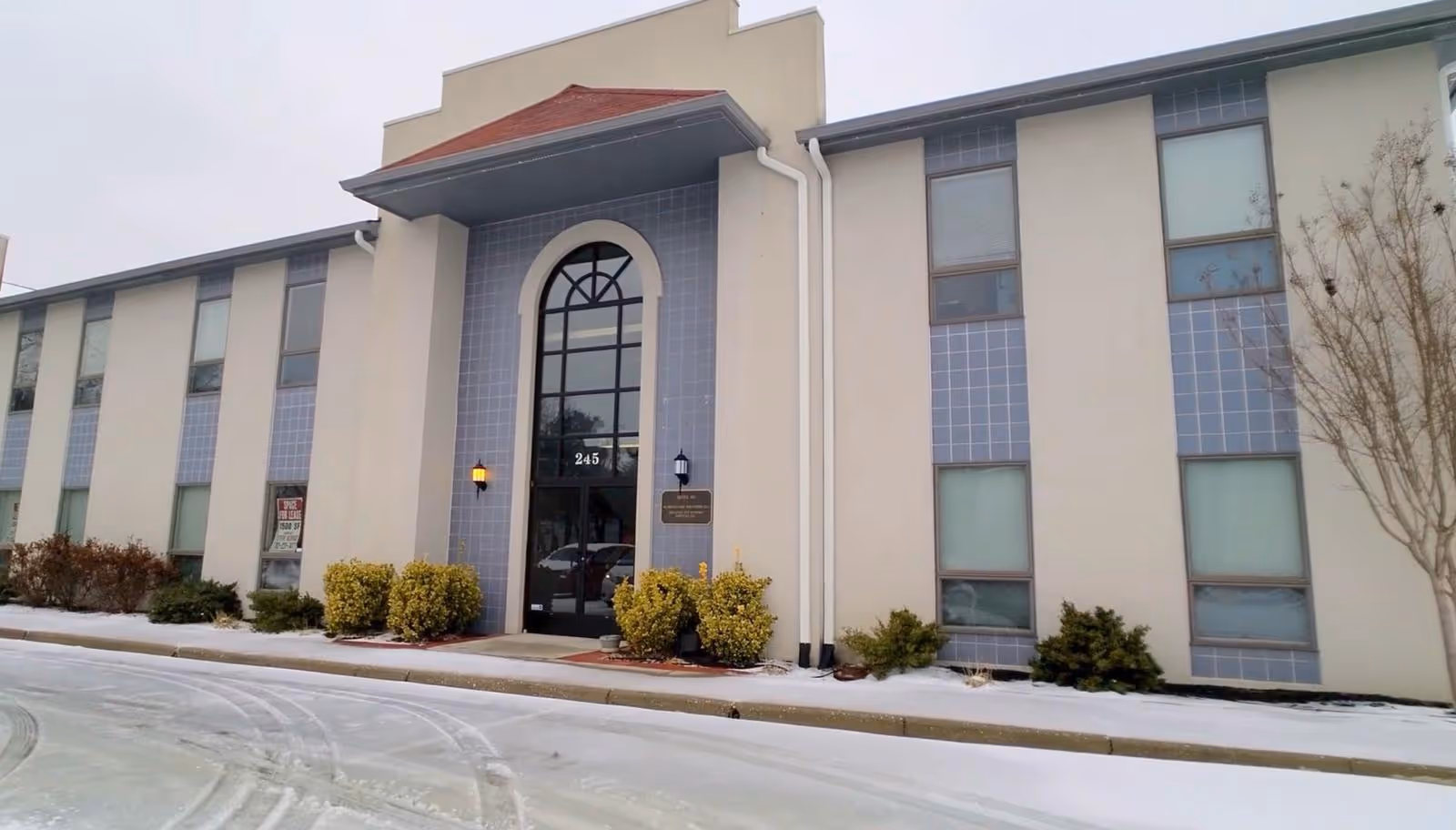 Aldrich Care Solutions facility building exterior with arched entrance and snow.