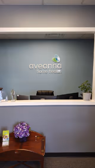 Reception desk in a blue lobby with Aveanna Home Health logo on the wall.