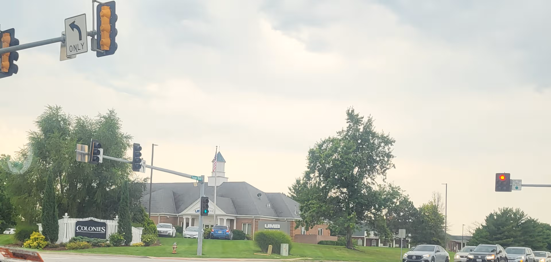 Exterior view of Colony Pointe Senior Living building along a road with traffic lights.