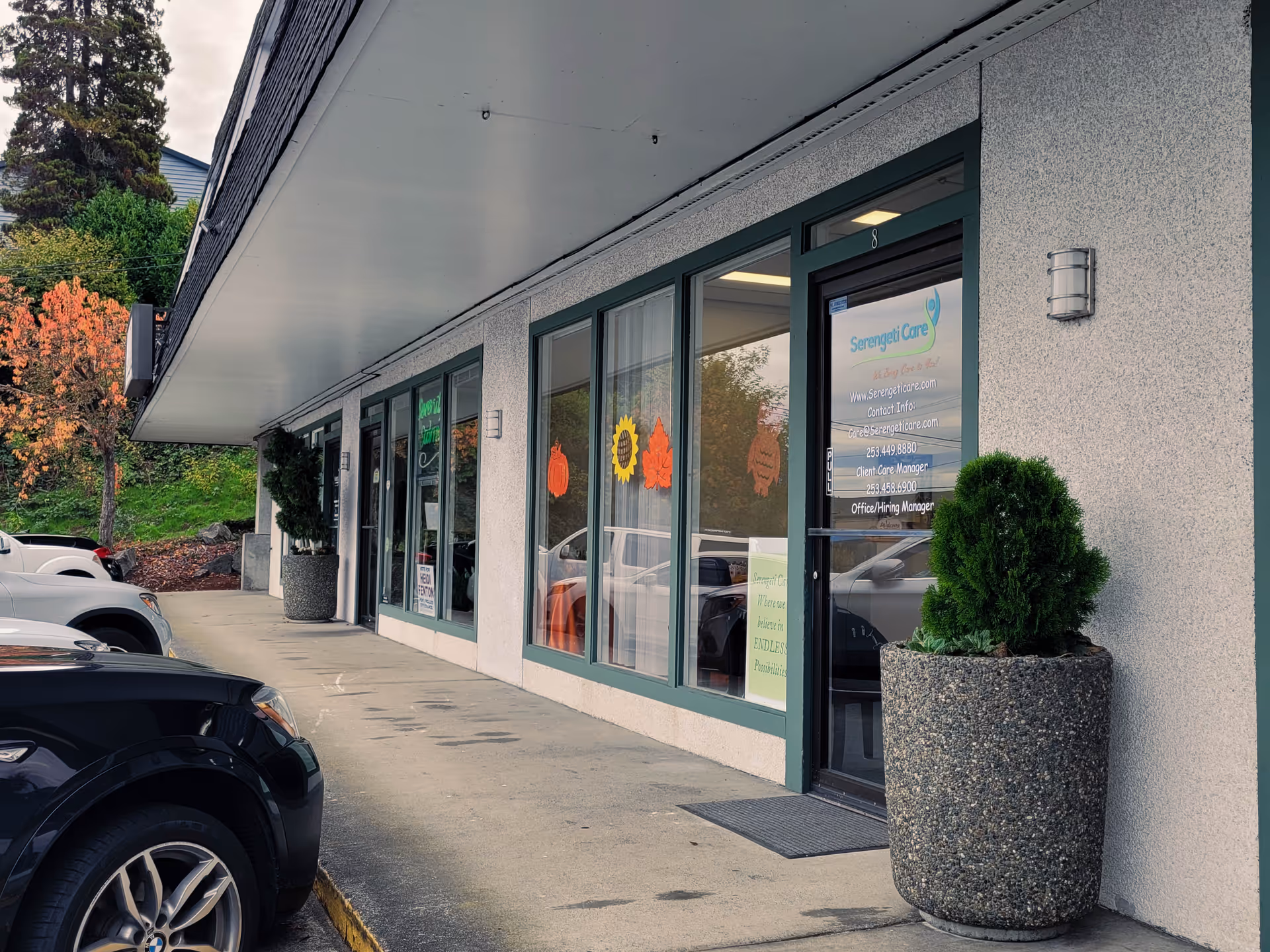 Exterior view of Serengeti Care storefront with glass windows and planters.