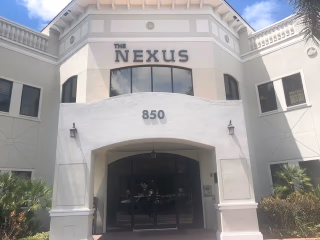 Tall white building entrance with The Nexus sign and 850 address.