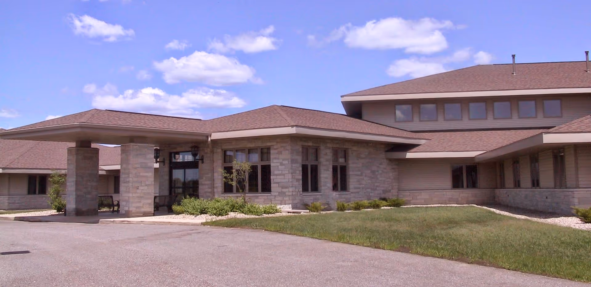 Exterior view of Crest View senior living facility with stone facade and entrance canopy.