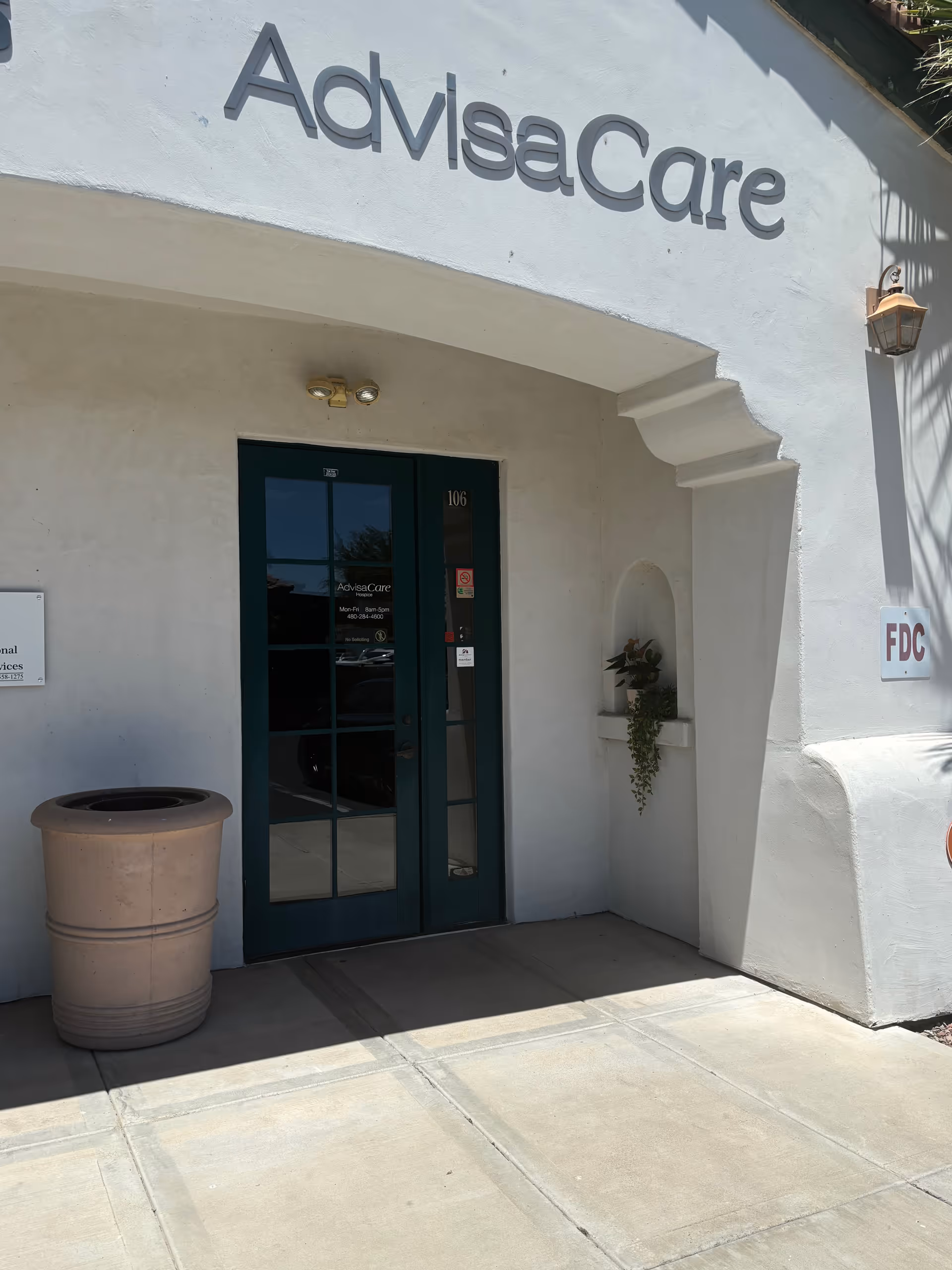 Entrance of AdvisaCare building with a glass door and large sign.